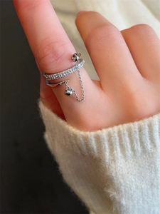Detail van zilveren gelaagde ring met zirkoon en hangend metalen bal aan fijne ketting
