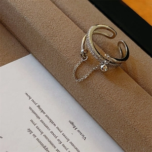 Macro-opname van zilveren dubbele ring met zirkonia en een hangende ronde bedel