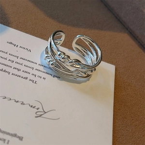 Detailweergave van de gevlochten zilveren ring met gedraaide textuur op lederen achtergrond