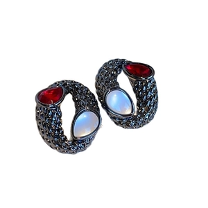 Vintage style earrings with red and white teardrop gems on black textured metal frame
