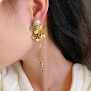Macro shot of 18K gold-plated floral pearl earrings with long tassels on model