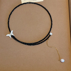 Detail eines Vintage-Perlen-Chokers mit weißem Schmetterling und Perlenbesatz