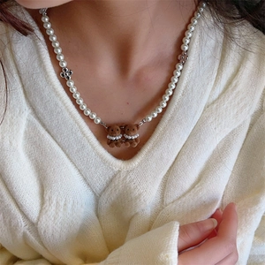 Detail der Perlenkette mit braunen beflockten Bärenanhängern und silbernen Blumen