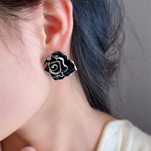 Detailed close-up of a black enamel camellia earring with a micro-inlaid zircon center