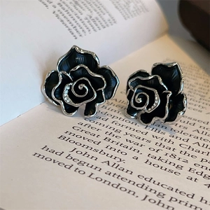Elegant s925 silver black enamel rose earrings with rhinestones on a vintage book page