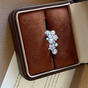 Macro shot of silver cluster earrings with pearls and star-shaped cubic zirconia in a jewelry box