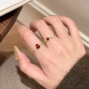 Detail of red agate gourd rings with sparkling zircons worn together on hand