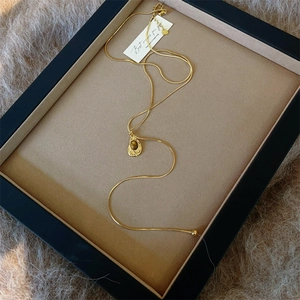 Retro tiger eye stone necklace with gold snake chain on a brown velvet display tray