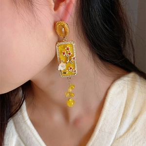 New Chinese style floral relief earrings with golden tassels on a female model