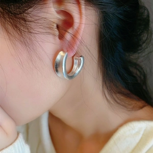Minimalist matte silver C-shape earrings with brushed metal finish on model