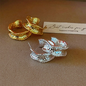 Irregular C-shaped earrings with hammered texture in gold and silver finish