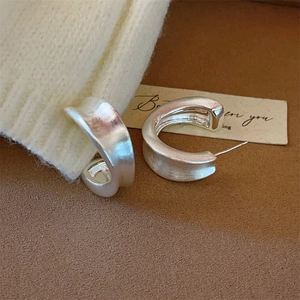 Brushed silver C-shaped chunky hoop earrings with an irregular wide matte finish