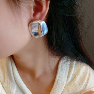 Modern brushed silver irregular geometric stud earrings for women on a model