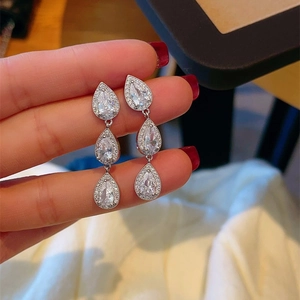 Close-up of sparkling silver drop earrings featuring triple-layered cubic zirconia stones