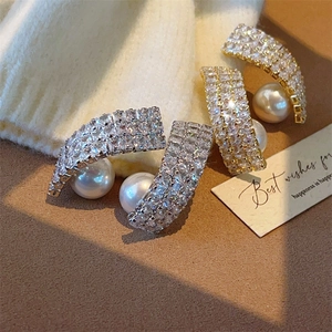 Elegant gold and silver twisted pearl drop earrings with sparkling pavé cubic zirconia