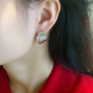 French luxury curved C-shape silver earrings with pearl on a model in nature