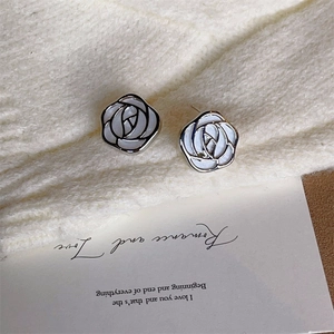 Vue détaillée de boucles d'oreilles rose argentées au lustre nacré sur tricot blanc