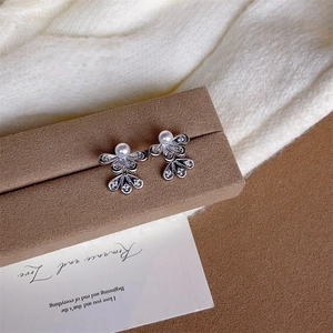 Elegant silver flower stud earrings with double-layered pavé petals and central pearl