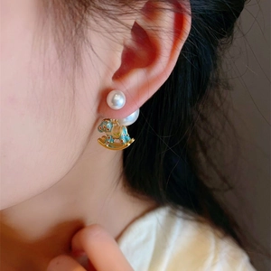 Elegant rocking horse earrings with blue enamel and pearls on model for a chic look
