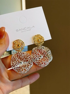Detail of gold and silver textured hollow radiator earrings on a display card