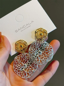 Detailed shot of large geometric hollow grid earrings in gold and silver contrast plating