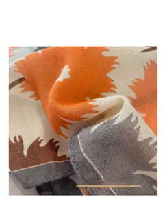 Gros plan d'une écharpe en coton et lin avec motif de feuilles et bords surjetés
