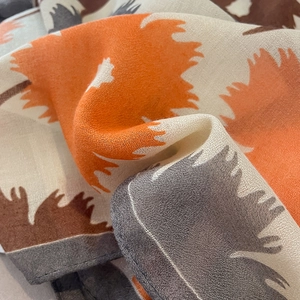 Gros plan d'une écharpe légère en coton et lin avec des motifs de feuilles d'automne
