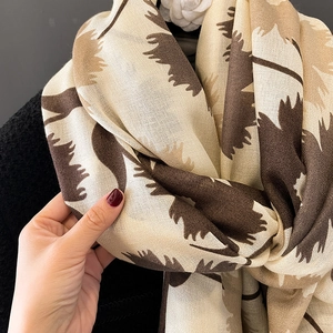 Détail de la texture d'une écharpe imprimée en coton et lin sur un manteau noir