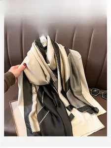 Detail showing geometric color-block silk scarf with black, gray and cream diamond pattern