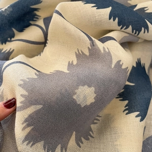 Gros plan d'une écharpe en coton et lin montrant la texture délicate du motif fleuri