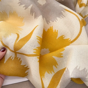 Détail de l'écharpe en coton et lin respirante avec motifs floraux et texture douce