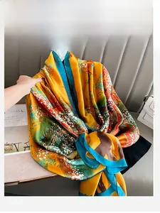 Detailed close-up of a long floral silk scarf with abstract patterns and fine edges