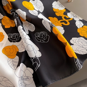Détail d'un foulard en satin à imprimé camélia avec bords ourlés soignés en gros plan