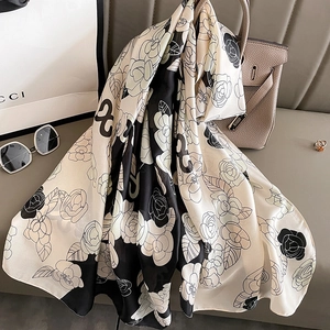Détail d'une écharpe élégante en satin noir et blanc avec motifs de roses et blocs géométriques