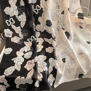 Détail d'une écharpe en soie avec motif de camélia et papillon en noir et blanc