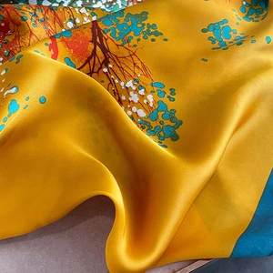 Detail of soft silk scarf texture with vibrant yellow and blue abstract nature print