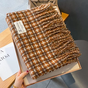 Détail de l'écharpe à carreaux orange montrant la texture épaisse et les franges