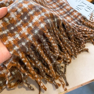 Gros plan d'une écharpe à carreaux rétro en texture cachemire avec bords frangés