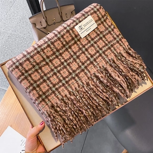 Détail d'une écharpe à carreaux imitation cachemire avec de longues franges et étiquette