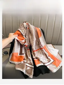 Dettaglio di un elegante foulard di seta con motivi geometrici arancioni e marroni