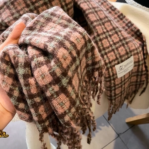 Détails d'une écharpe à carreaux rose et marron avec de longues franges à la main