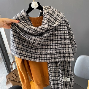Écharpe classique à carreaux noir et blanc avec franges sur un cintre