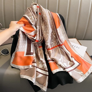 Sciarpa di seta elegante con motivi floreali e geometrici in tonalità arancio