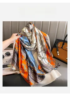 Detail of luxury silk scarf with chain pattern draped over a knit sweater