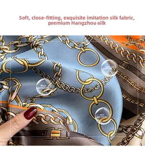 Close-up of soft faux silk scarf with blue and orange chain print and silky texture