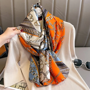 Silky fashion scarf with chain and belt print on beige knitwear for autumn styling