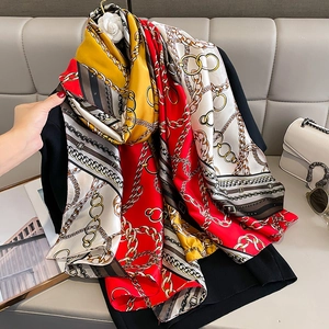 Detail of silk-like scarf featuring vintage gold chain patterns and bold color blocking