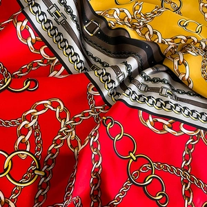 Detail of silk-like scarf with vintage gold chain and red-yellow geometric pattern