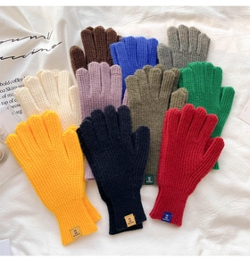 Close-up of thick waffle-knit gloves in vibrant colors with stitched label and ribbed cuffs