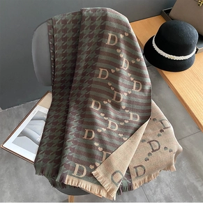 Detail of double-sided houndstooth scarf with letter D patterns and soft fringe trim